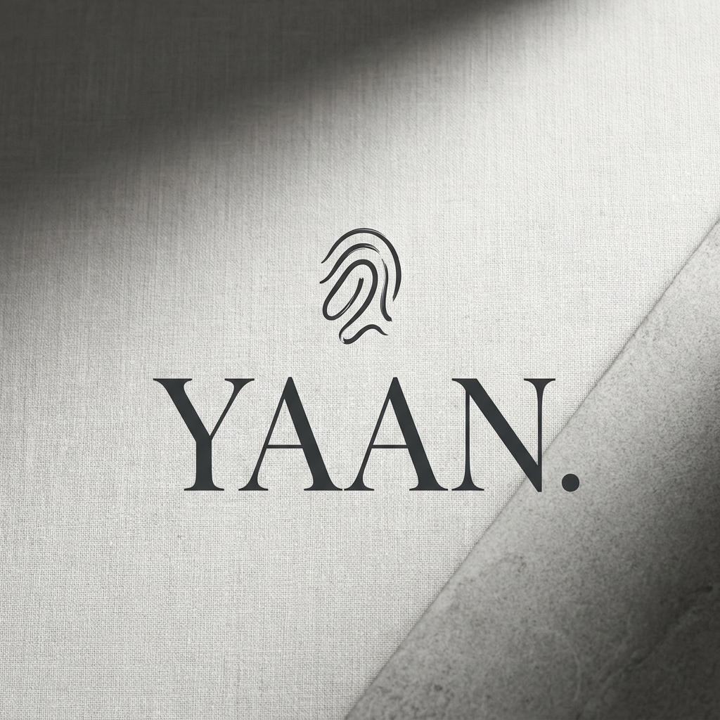 AI Design for A sophisticated and minimalist luxury logo for a high-end clothing brand named YAAN, featuring elegant, clean typography with high-contrast serif lettering. The design should feel timeless and premium, incorporating a subtle, abstract icon that represents the concept of self-expression, set against a monochromatic textured background with soft, dramatic studio lighting.