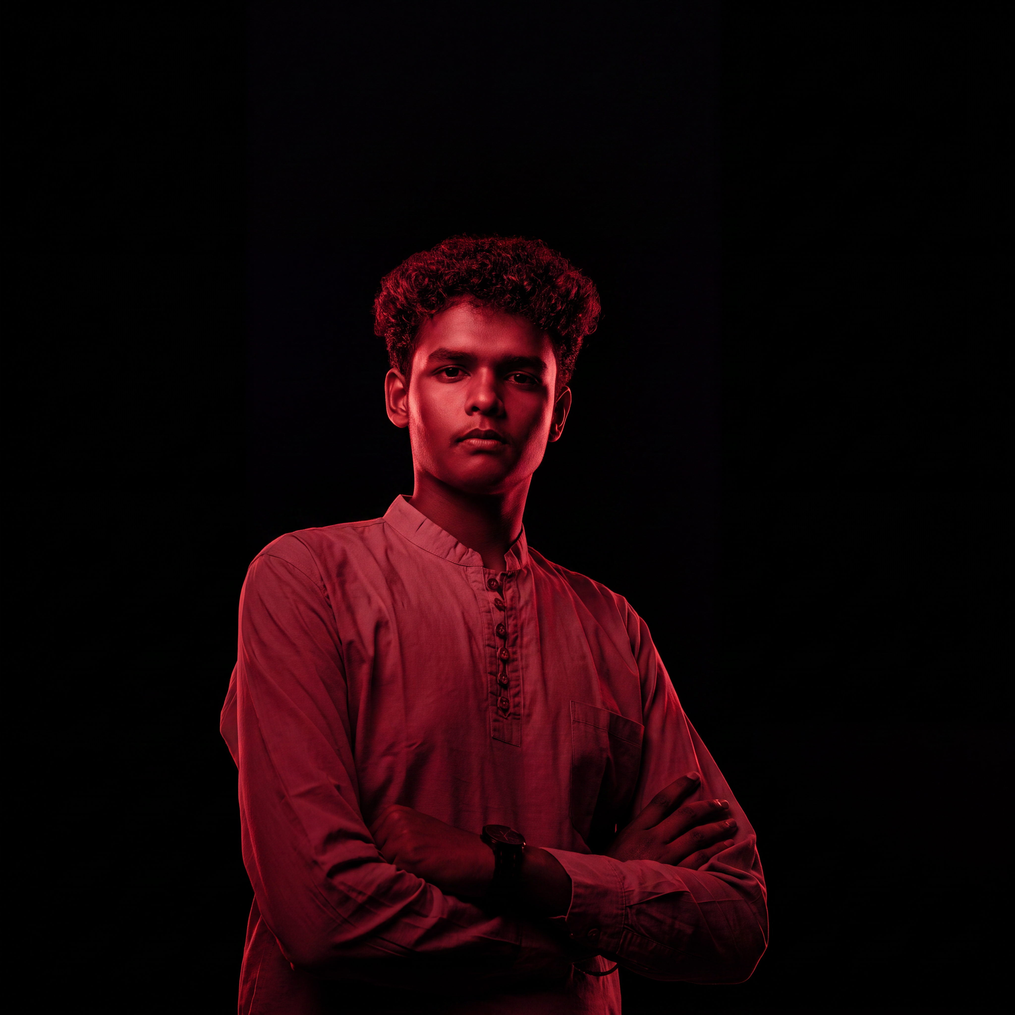 AI Design for Cinematic portrait, straight-on facial expression, hyper-realistic skin texture. Dramatic duotone lighting using only deep matte black (#000000) and rich crimson red (#B00020). Intense crimson directional side lighting sculpting the cheekbones, jawline, and hair texture, transitioning into deep black shadows on the opposite side. Minimalist, solid black background. Premium luxury fashion editorial aesthetic, high-contrast film noir style, sharp facial details, volumetric lighting, 8k resolution, photorealistic, no text, no logos. Use the attached image as the primary composition and structural reference.