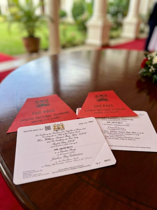 AI Design for Change name from Gerald Mithamo Muchiri to Aron Bett. Change the background from a car steering as seen to a state house table or laps