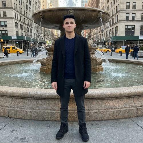 AI Design for Szerkeszd meg ezt a képet úgy hogy állok 1 helyen Newyorkba valami szép szökőkutnál. Armani kabátba alul kötött ralp lauren pulóverbe, Jordan 4 cipőbe. Illetve az arcot ne torzitsd el ez az én arcom, minden legyen realisztikus. Illetve a nadrág legyen valami elegáns. Az arcom élénkebb mint az eredeti képen