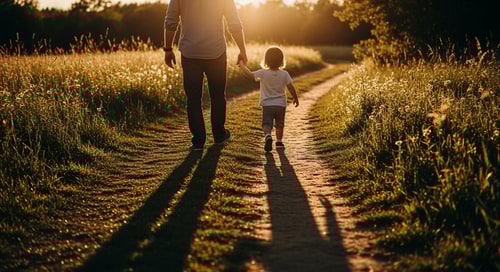 AI Design for A father and young child walk hand in hand away from the viewer — Centered rear-view composition from a low-angle perspective, Natural earthy tones with warm golden-hour highlights, Sentimental and peaceful mood with soft sunlight casting long shadows, High-resolution cinematic photography with a shallow depth of field, Keep faces completely hidden and focus on the connection of the hands, A gentle dirt path leading through a sun-dappled meadow at sunset.