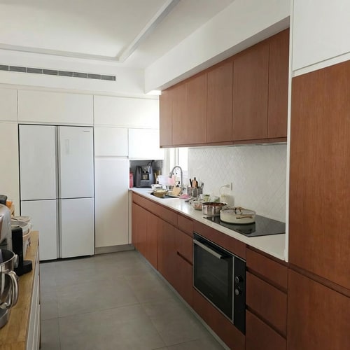 AI Design for Change the refrigerator color to white.
• Reduce the refrigerator depth so it is fully flush with the cabinetry. Currently, the refrigerator protrudes 10 cm beyond the cabinet line; it should not protrude at all.
• On the opposite side, change the finish of the tall cabinets to a brown tone.
• Lower the height of the tall cabinets so they match the height of the tall cabinets in the refrigerator area, creating one consistent height for all tall cabinets in the kitchen.
• Continue the wall line above the cabinets so it wraps around them, creating a framed and cohesive look.