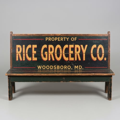 AI Design for A vintage wooden bench designed as an old general store advertising sign, perfectly front-facing (orthographic view, no perspective distortion). The bench looks symmetrical and centered. The top panel is clearly visible like a flat sign. Hand-painted vintage typography reads: “PROPERTY OF” (small, top), “RICE GROCERY CO.” (large, bold centerpiece in warm yellow/orange with red shading), and “WOODSBORO, MD.” (smaller below). The wood is aged and slightly worn with visible grain and distressed paint. Colors include dark green, black, and rustic tones. The bench legs are simple and visible beneath. Studio lighting, neutral background, highly detailed, realistic texture, no angle, straight-on view.
