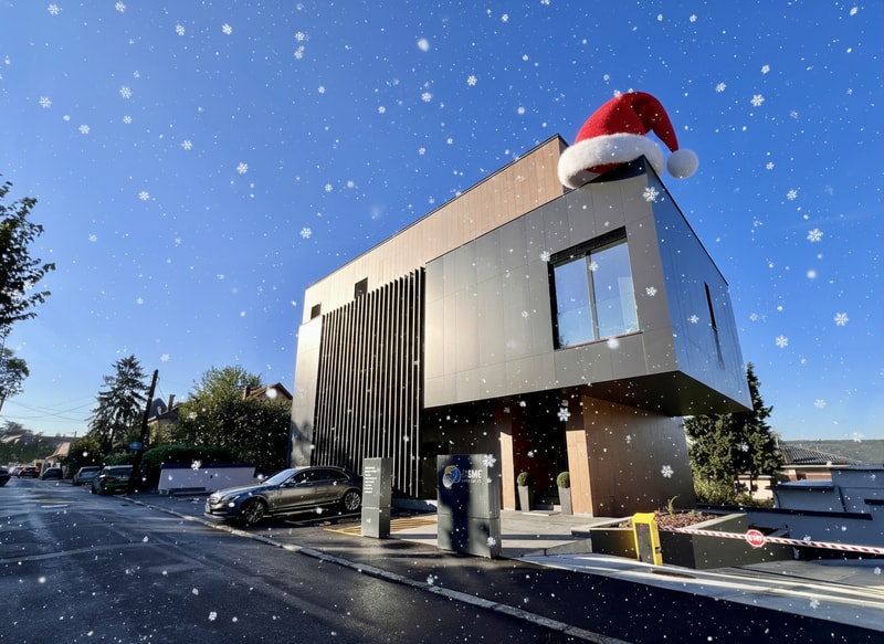 Add a realistic animation where a Santa hat gently falls onto the roof of the building, while soft snowflakes slowly fall around. The atmosphere should feel festive and wintery, with gentle motion, cinematic lighting, and realistic snow effects.”