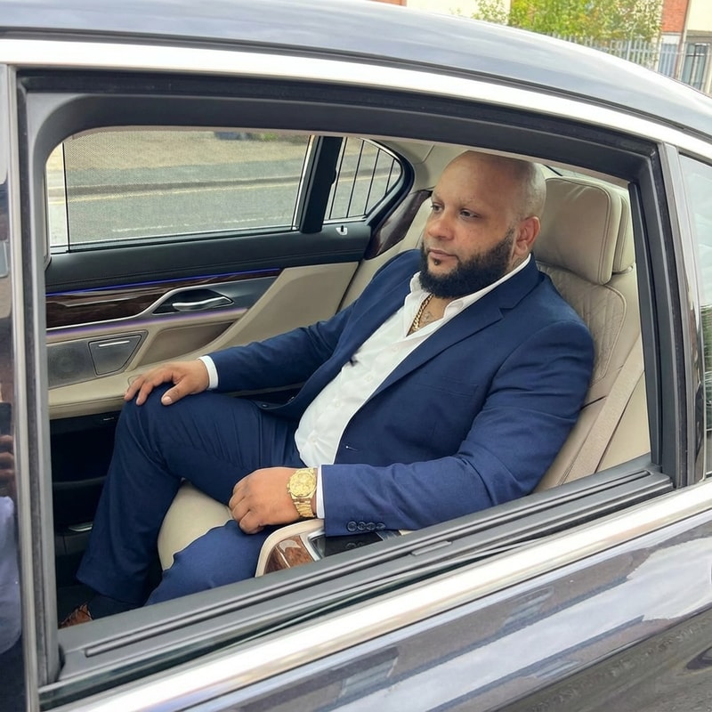 Szerkeszd meg ezt a képet úgy benne ül 1 BMW luxus osztályban. Arany nyaklánc és karóra legyen rajta és a kép 100%-ban valódi legyen az arc minden hasonlitson. Távoli kép legyen, legyen rajta 1 zara ruházat