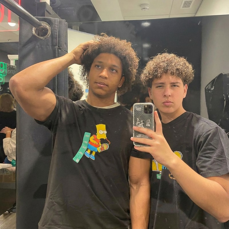 quiero que el chico de la izquierda tenga un poco mas grande los brazos y con la misma pose, sin cambiar caras