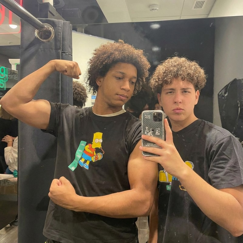 quiero que el chico de la izquierda tenga mas musculos en los brazos pero sin exagerar.