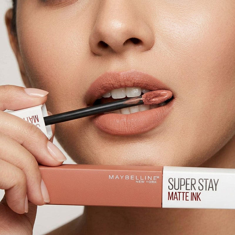 same indian fair skin tone model applied good mackup keeps lipstick product on her mouth between both teeth and down teeth visible only less and she holding that